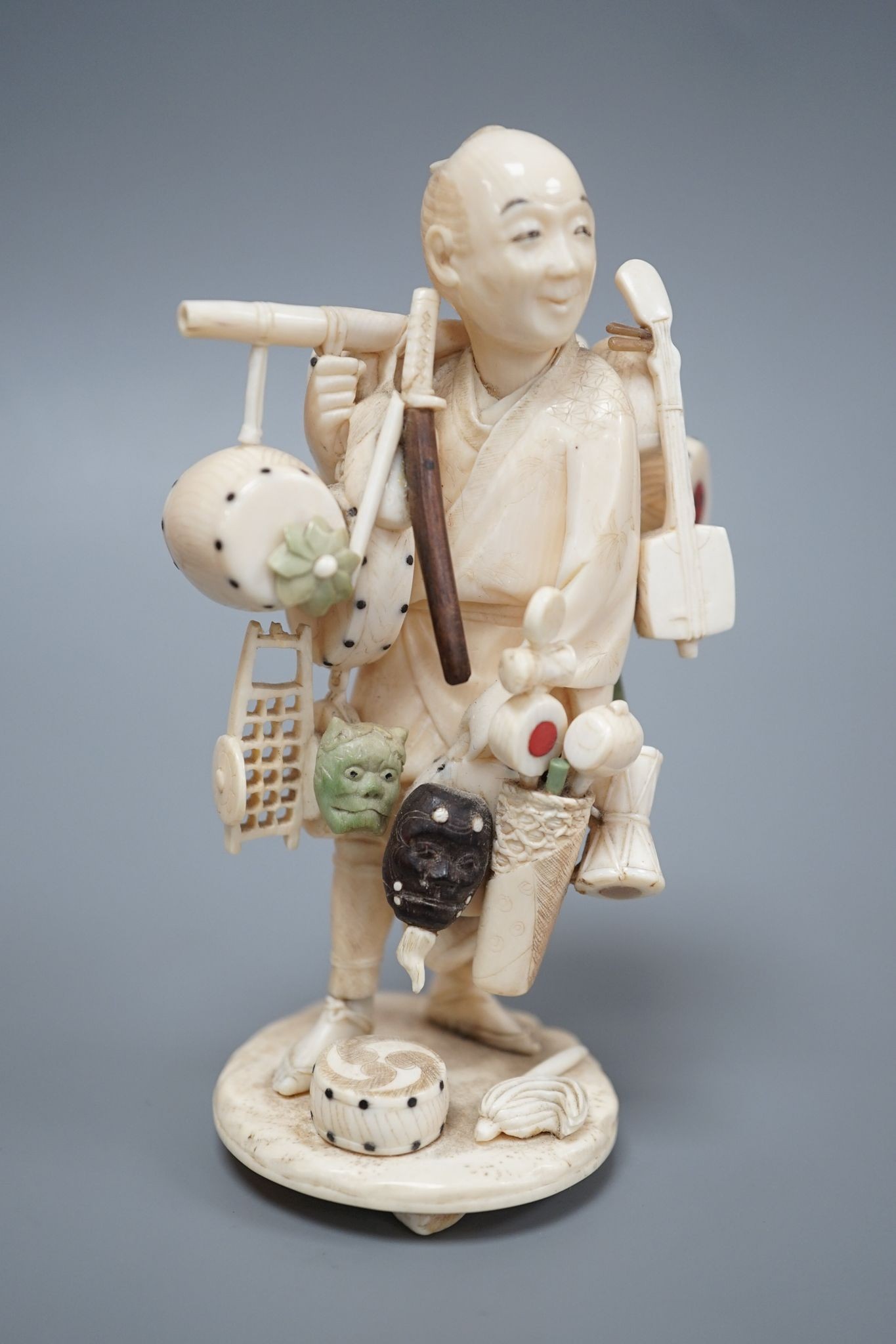 A Japanese ivory okimono of a street vendor, early 20th century 12cm